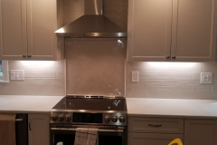 Off White Cabinets with Herringbone tile over the range
